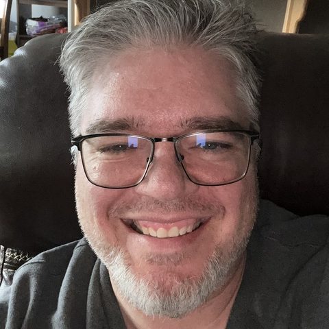 Clifton McNeill, smiling, wearing glasses